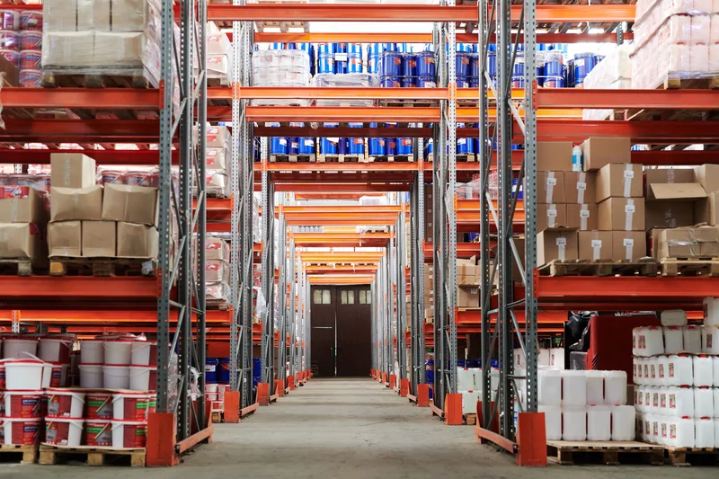 A wide aisle between stocked warehouse racks.